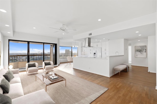 living area featuring baseboards, wood finished floors, visible vents, and recessed lighting