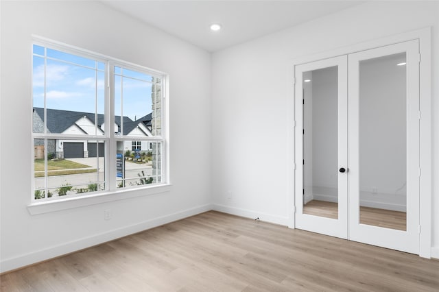 unfurnished bedroom with a closet, light wood-type flooring, and french doors