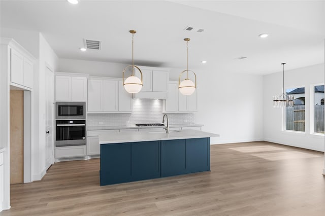 10914 Prospect Hill Ct, Missouri City, TX 77459 - kitchen featuring stainless steel appliances, light countertops, white cabinetry, decorative backsplash, and light wood-style floors