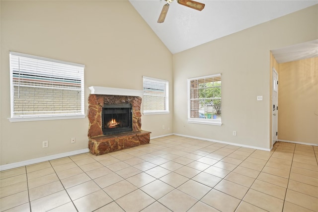 unfurnished living room with ceiling fan, high vaulted ceiling, light tile patterned floors, and a fireplace