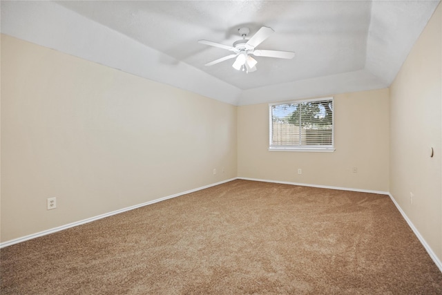 unfurnished room featuring vaulted ceiling, ceiling fan, a raised ceiling, and carpet floors