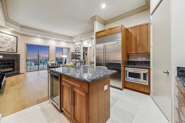 3388 Sage Rd Unit 2401, Houston, TX 77056 - kitchen with built in appliances, beverage cooler, crown molding, dark stone countertops, and open floor plan