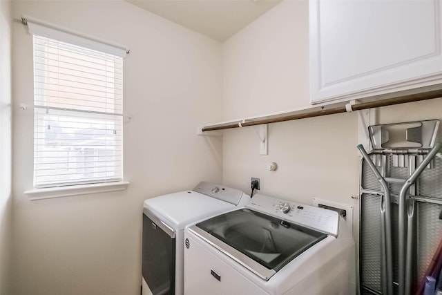 clothes washing area featuring cabinets and independent washer and dryer