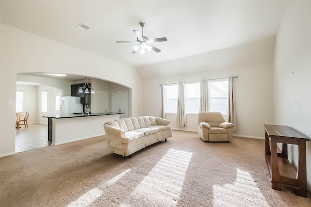 carpeted living room with ceiling fan, lofted ceiling, and sink