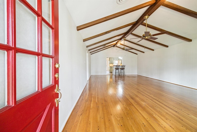 unfurnished living room featuring ceiling fan, hardwood / wood-style flooring, and lofted ceiling with beams