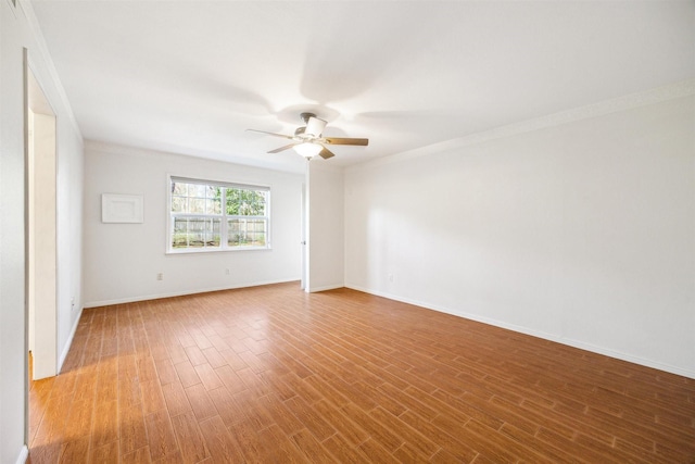 unfurnished room with ceiling fan, wood-type flooring, and crown molding