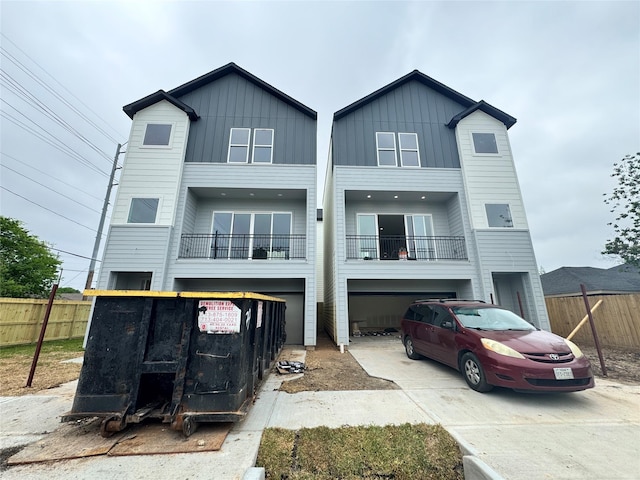 view of front facade with driveway, a garage, and fence