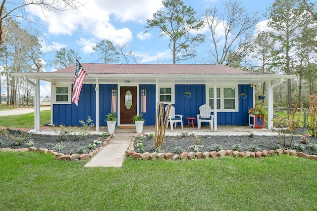 view of front facade with board and batten siding, a porch, and a front lawn