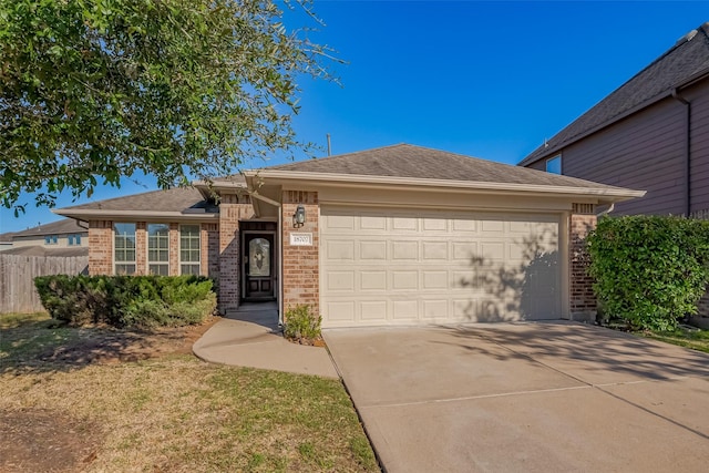 single story home featuring concrete driveway, brick siding, fence, and an attached garage