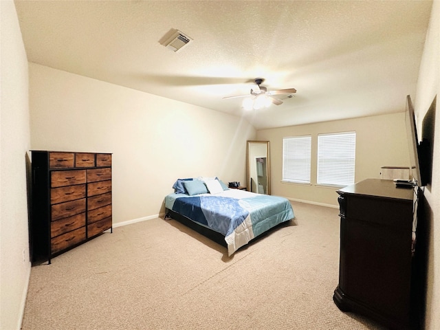 carpeted bedroom featuring a textured ceiling and ceiling fan