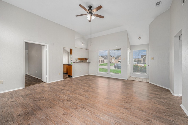 unfurnished living room with dark wood-type flooring, ceiling fan, and high vaulted ceiling