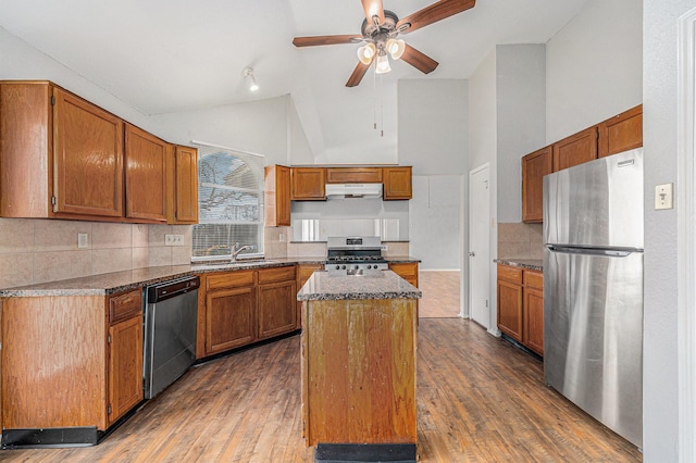 kitchen featuring sink, appliances with stainless steel finishes, dark hardwood / wood-style floors, tasteful backsplash, and a kitchen island