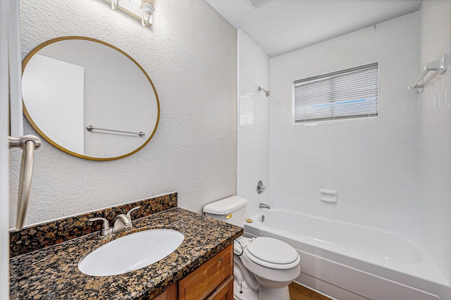 full bathroom featuring vanity, tiled shower / bath, and toilet