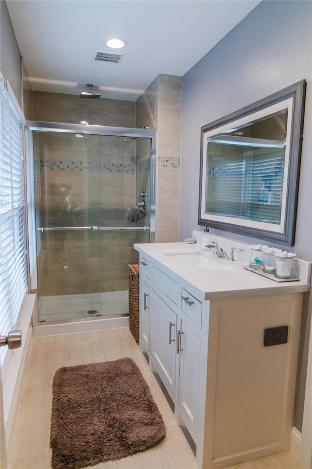 bathroom featuring a shower with door and vanity