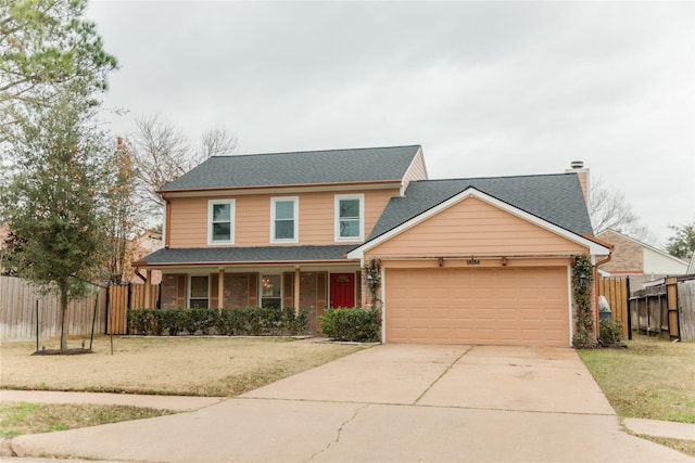 view of property with a garage, a front lawn, and a porch