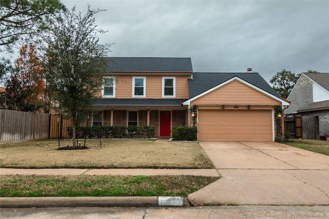 view of front facade with a garage, covered porch, and a front lawn