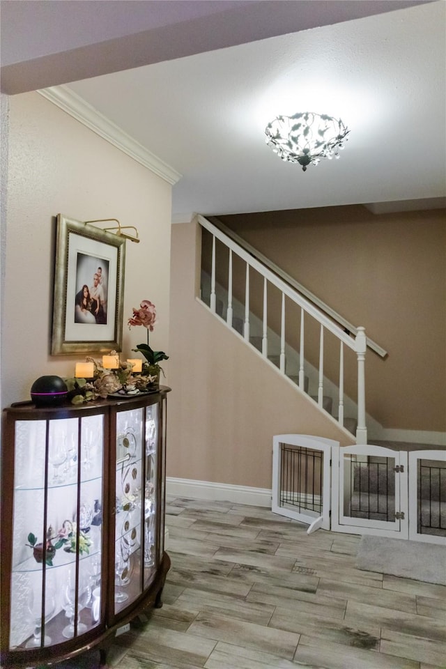 stairway featuring ornamental molding and wood-type flooring