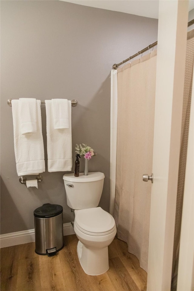 bathroom featuring a shower with shower curtain, toilet, and hardwood / wood-style floors