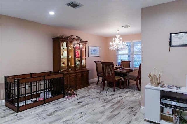 dining area with a chandelier and light wood-type flooring