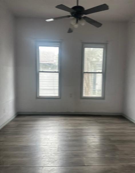 unfurnished room featuring dark hardwood / wood-style flooring and ceiling fan