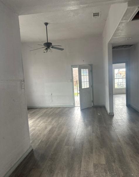 spare room featuring dark wood-type flooring, plenty of natural light, and ceiling fan