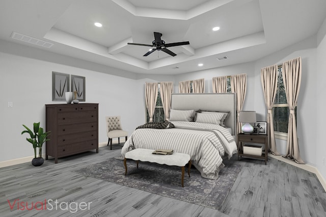 bedroom with a tray ceiling, ceiling fan, and hardwood / wood-style flooring