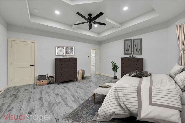 bedroom featuring coffered ceiling, a tray ceiling, ceiling fan, and light hardwood / wood-style flooring