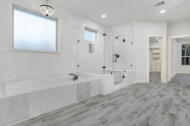 bathroom featuring wood-type flooring and separate shower and tub