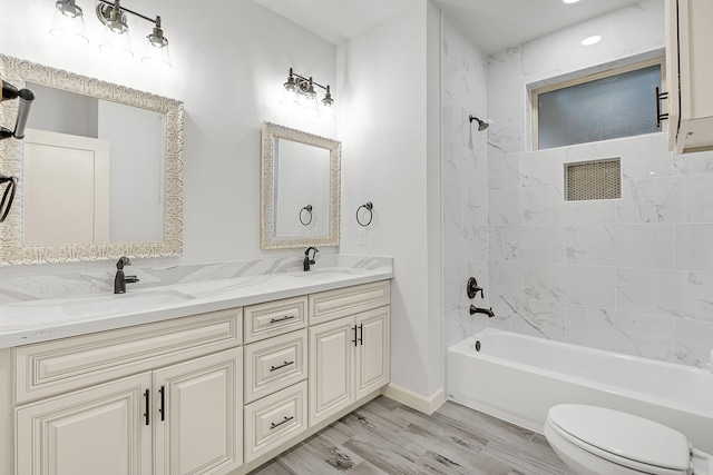 full bathroom featuring vanity, tiled shower / bath combo, toilet, and hardwood / wood-style flooring