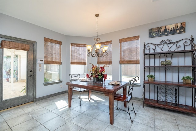 dining space with an inviting chandelier, light tile patterned floors, baseboards, and a wealth of natural light