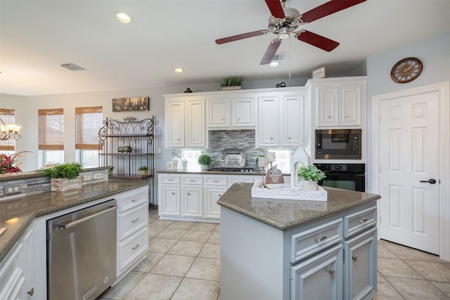 kitchen with appliances with stainless steel finishes, white cabinets, visible vents, and light tile patterned floors