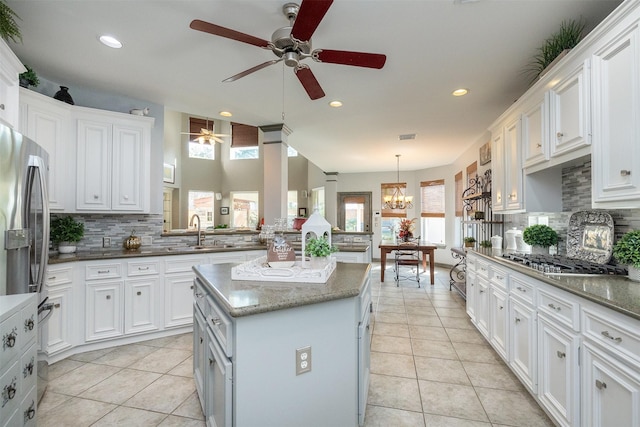 kitchen with stainless steel appliances, light tile patterned flooring, and white cabinets