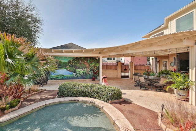 view of patio / terrace with an in ground hot tub, fence, a gate, and a pergola