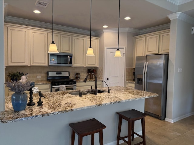 kitchen with sink, cream cabinets, stainless steel appliances, and light stone countertops