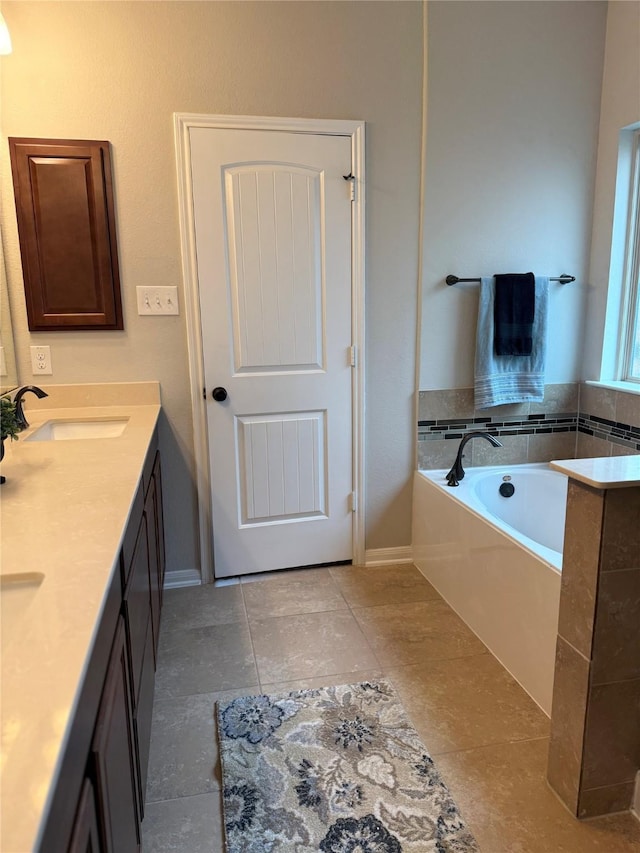 bathroom featuring a bathing tub, vanity, and tile patterned floors