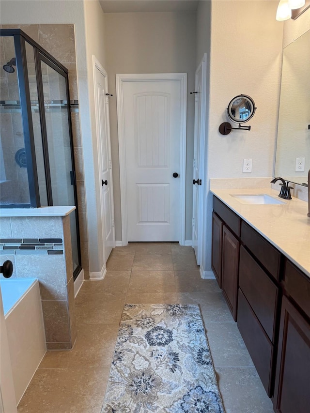 bathroom with tile patterned flooring, vanity, and walk in shower