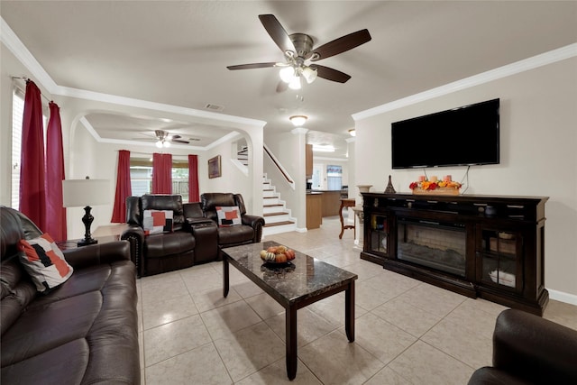 tiled living room with ornamental molding and ceiling fan