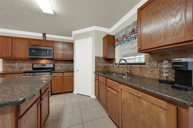 kitchen featuring stainless steel appliances, crown molding, sink, and dark stone counters