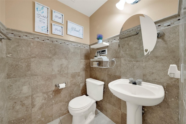 bathroom with tile walls, tile patterned floors, and toilet