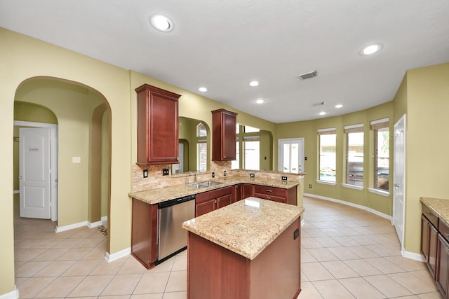 kitchen with light tile patterned flooring, a sink, stainless steel dishwasher, and dark brown cabinets