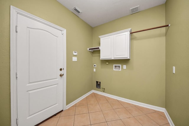 laundry area with light tile patterned floors, hookup for a gas dryer, visible vents, cabinet space, and electric dryer hookup