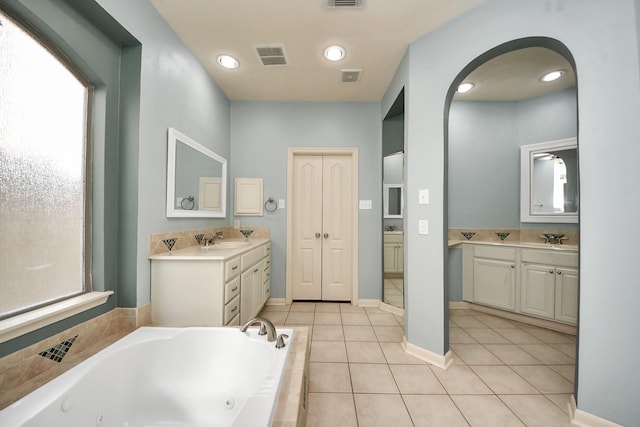 full bath featuring a jetted tub, a sink, visible vents, and tile patterned floors