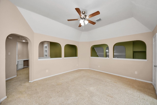 spare room with lofted ceiling, carpet, visible vents, and baseboards