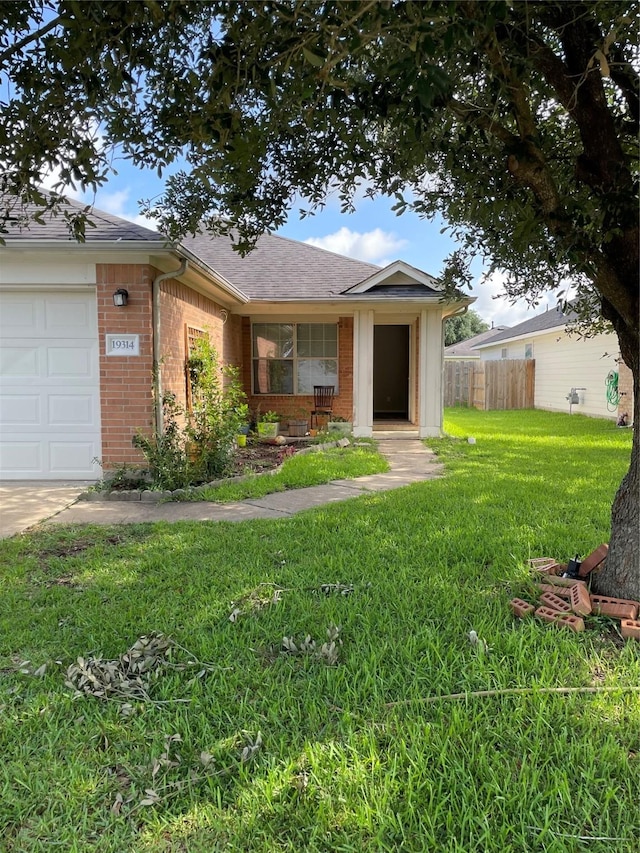 ranch-style home featuring a garage, a front yard, and covered porch