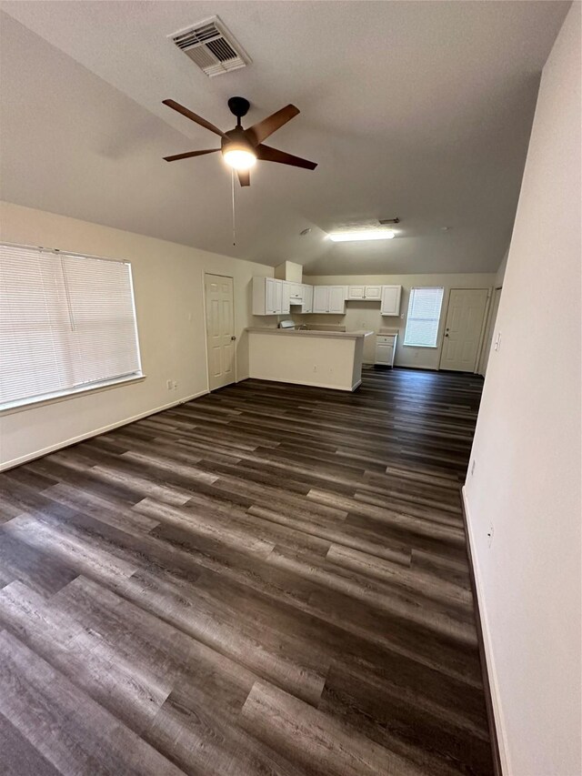 unfurnished living room featuring ceiling fan, dark hardwood / wood-style flooring, and a textured ceiling