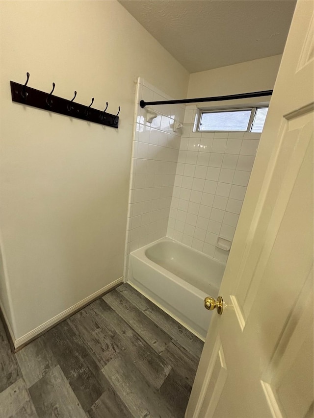 bathroom featuring wood-type flooring and tiled shower / bath