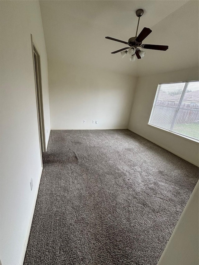 carpeted spare room featuring ceiling fan