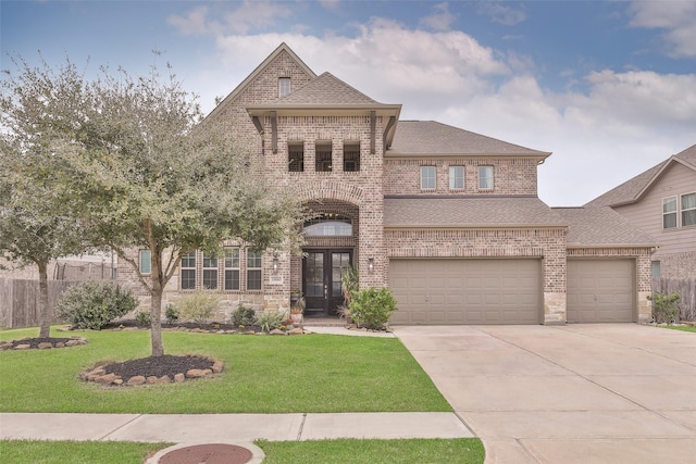 view of front of home with french doors, a garage, and a front lawn