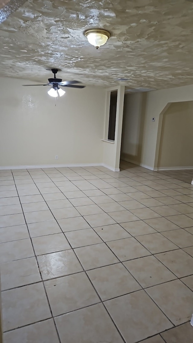 empty room with ceiling fan and light tile patterned flooring