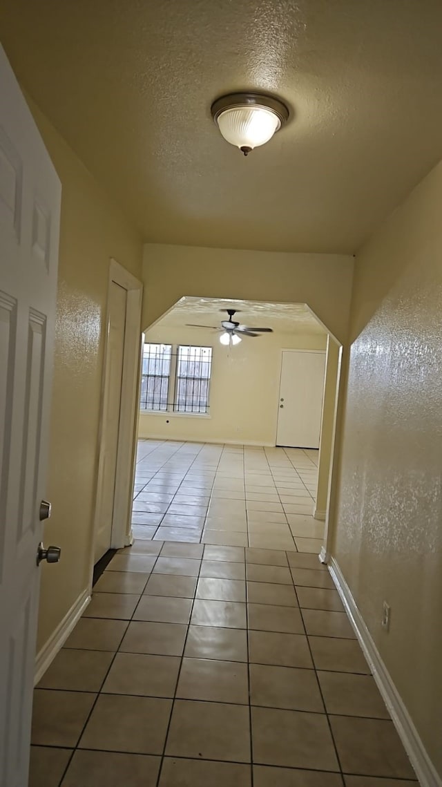 hallway with tile patterned flooring and a textured ceiling